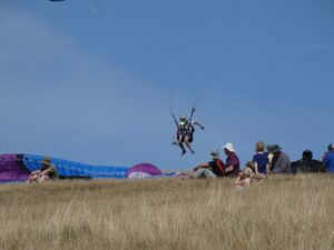 Mark landing a tandem flight with a small child on the Long Mynd